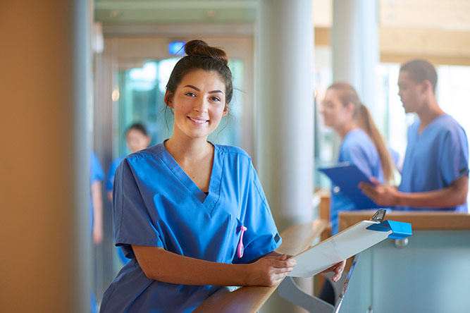 Nurse wearing a blue top & smiling