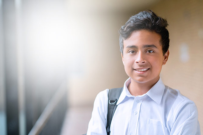 Kids carrying a bagpack and smiling