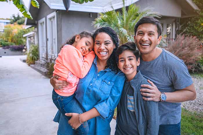 Happy family outside their home