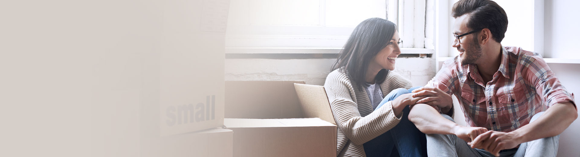 Couple sitting on the floor next to the boxes